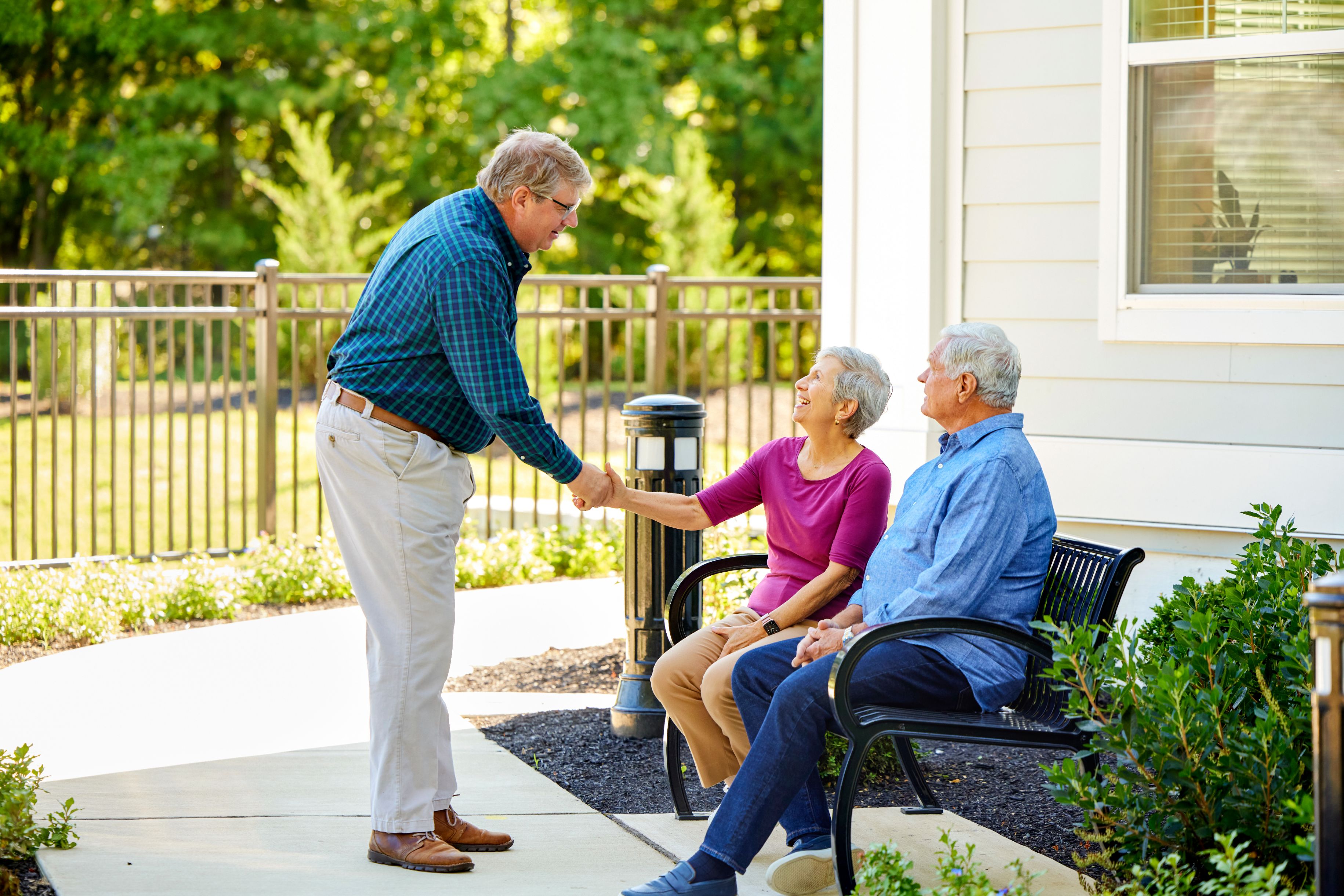 Arbor terrace employee shaking hands with couple smiling