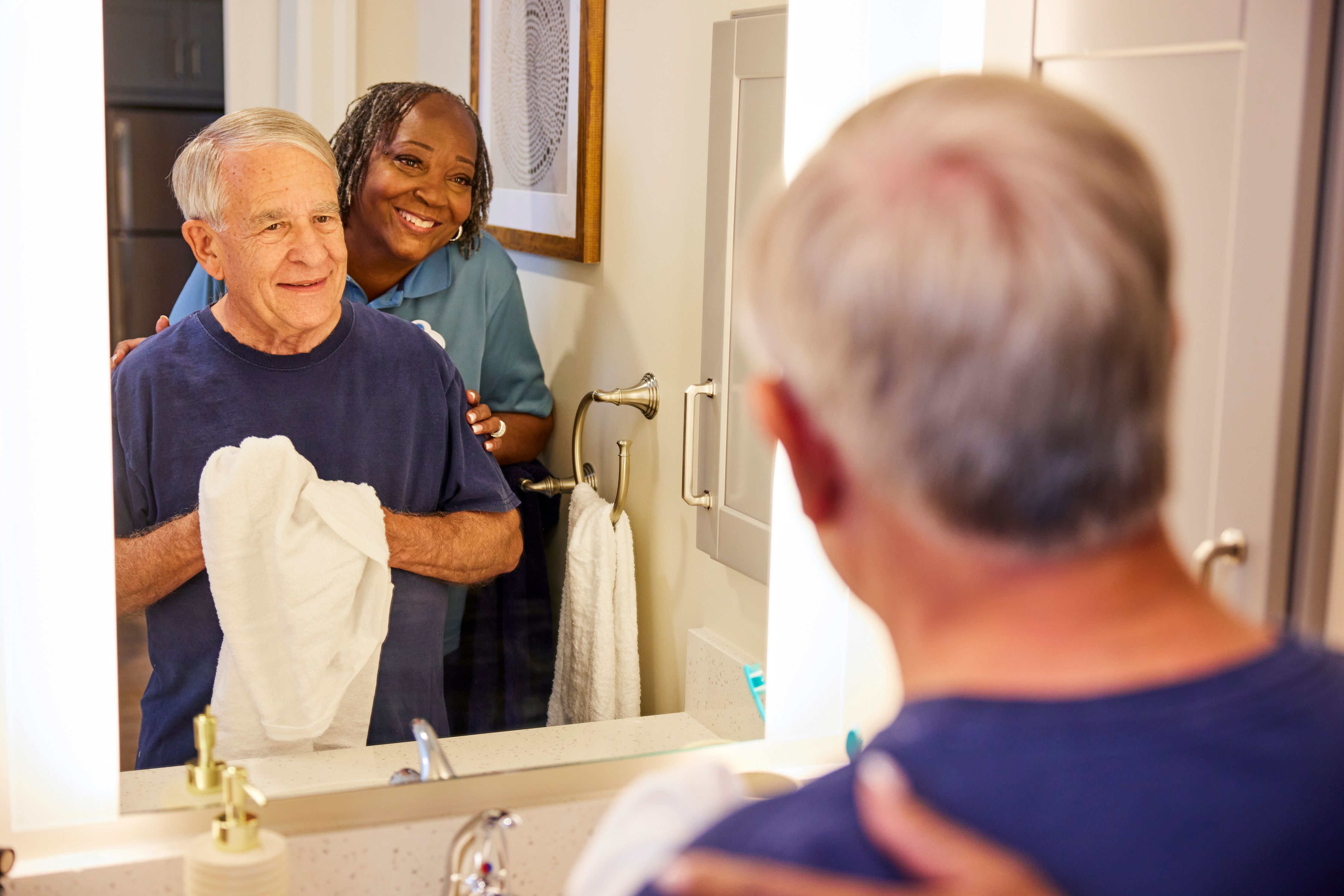 arbor terrace staff helping resident in apartment bathroom