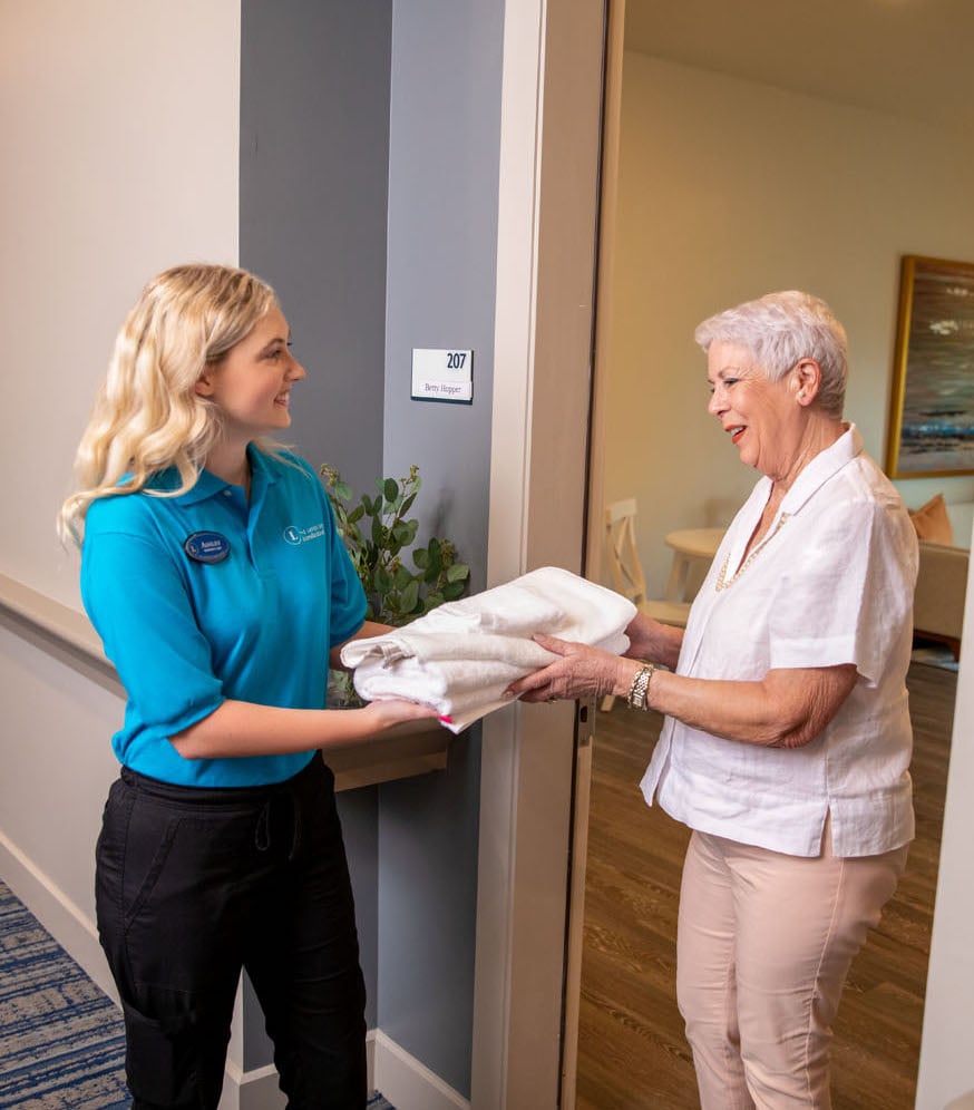 arbor terrace laundry staff handing towel to resident